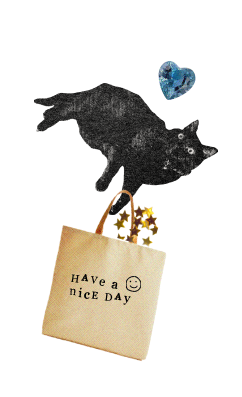 A black cat laying on its side with a paper bag hanging from its paw. The bag is printed with a smiley face and the words, 